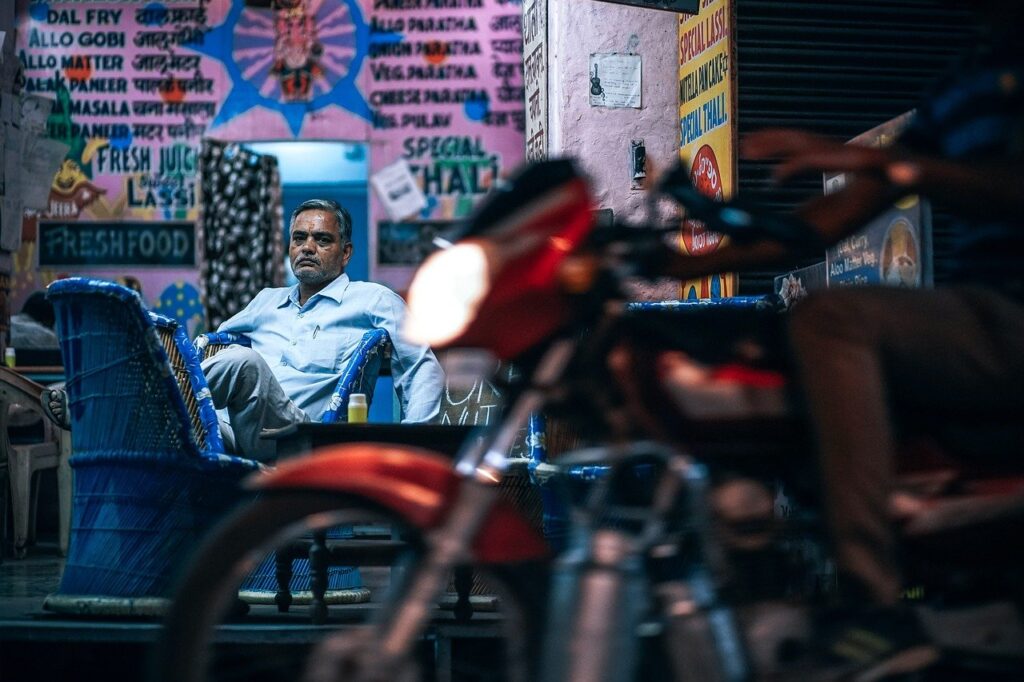Mężczyzna hinduskiego pochodzenia spogląda znad motocykla