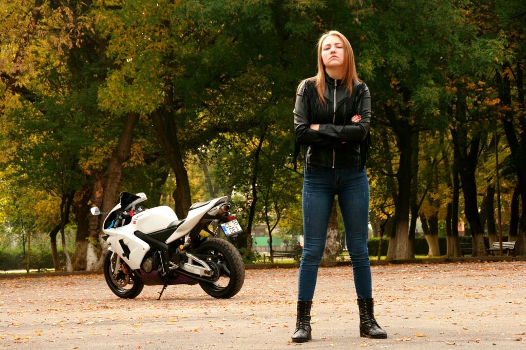 Kobieta stoi przy swoim motocyklu